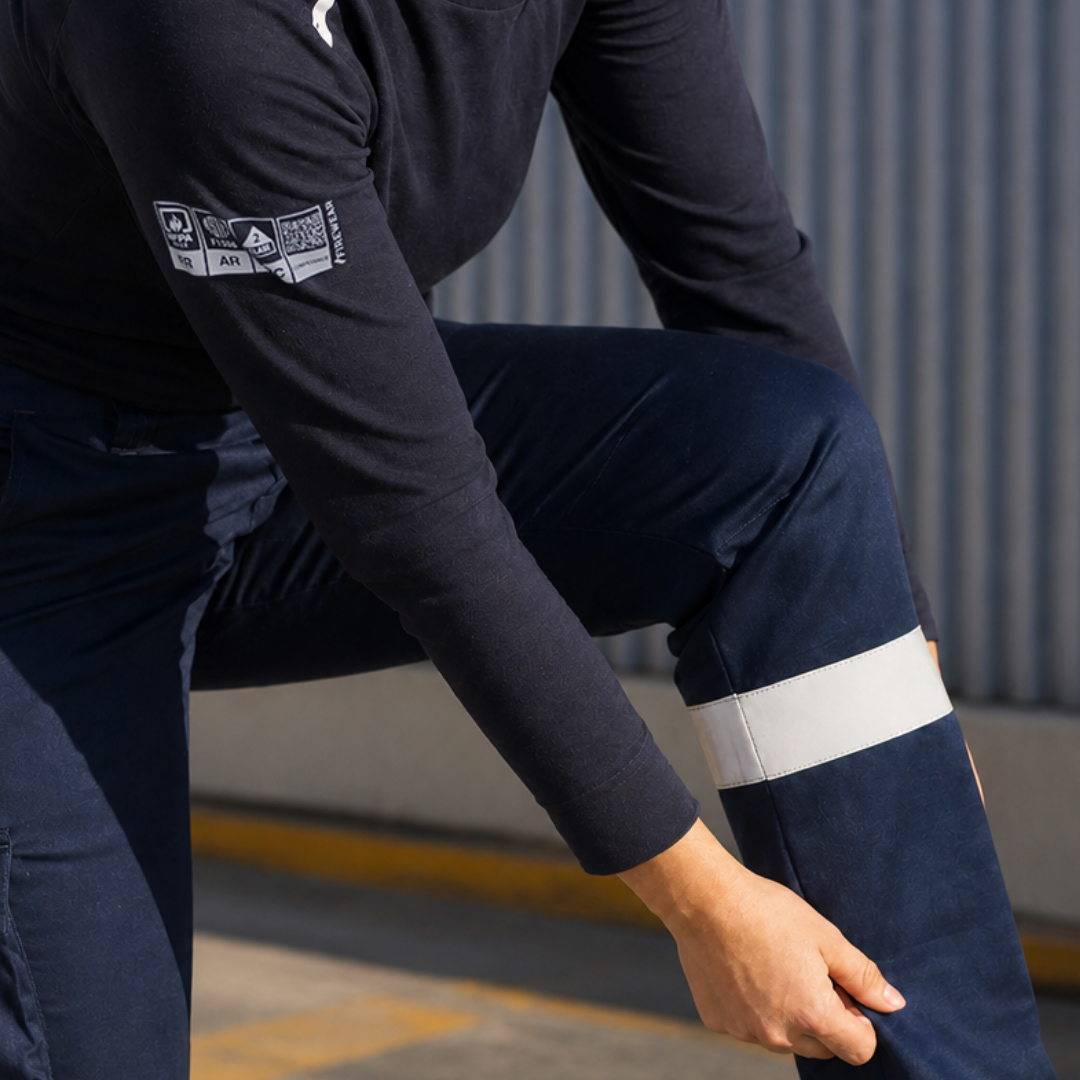 Detalle de rodilla y cinta reflectante de pantalón ignífugo FIREWEAR® azul marino para mujer.
